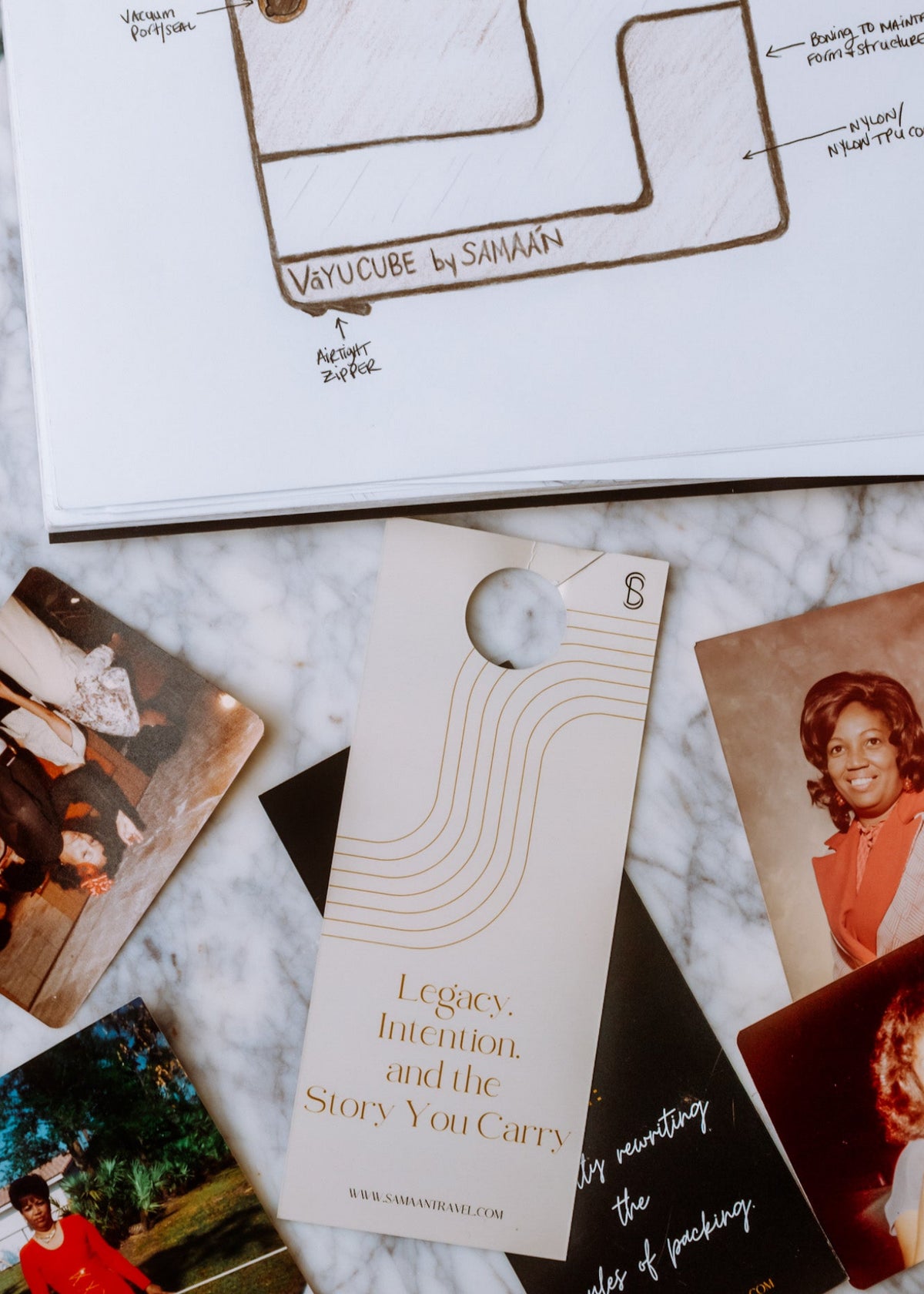 Collection of books and photos on a marble surface with 'VayuCube by Samaan' branding.
